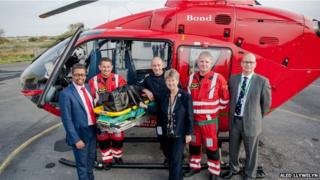 Chwith i'r dde: Dirprwy weinidog iechyd Vaughan Gething, parafeddyg Ambiwlans Awyr Cymru Jason Hughes, peilot Grant Elgar, gweinidog cyllid Jane Hutt, parafeddyg Gareth Williams a Dr Kyle Jacques, is gadeirydd ymddiriedolwyr Ambiwlans Awyr Cymru