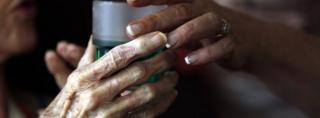 Nurse gives elderly woman a drink