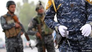 Сотрудник иракских сил безопасности проводит наблюдение за контрольно-пропускным пунктом с использованием поддельного устройства обнаружения взрывчатых веществ в районе Багдада аль-Джадрия 3 мая 2013 года.
