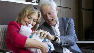 Билл и Хиллари Клинтон держат свою внучку Шарлотту.
