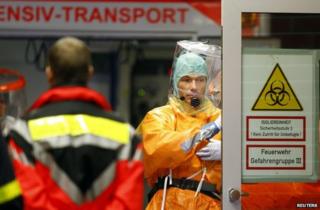 Medical staff in protective equipment attend the arrival of an Ebola patient at Frankfurt University Hospital, 3 October
