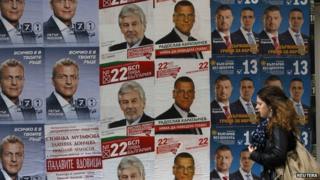 A woman walks past election posters in Sofia. Photo: 3 October 2014