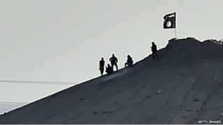IS fighters fly a flag on outskirts of Kobane