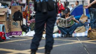 Pro democracy protester reads a newspaper at Hong Kong's Mongkok district