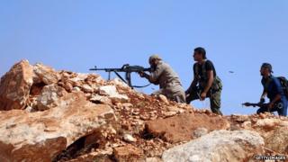 Rebel fighters fire towards Syrian government soldiers in the area of Handarat north of the northern city of Aleppo, on 3 October 2014