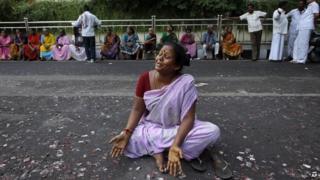 A supporter of former Tamil Nadu chief minister Jayaram Jayalalitha wails sitting on a road after a court rejected Jayalalitha's plea for bail in Chennai, India, Tuesday, Oct. 7, 2014.