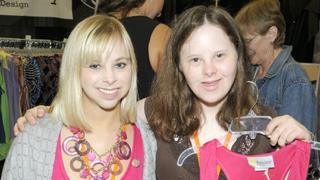 Ashley with another woman who is holding up one of her tops