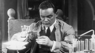 A wide-eyed German scientist performs an experiment in a German film.
