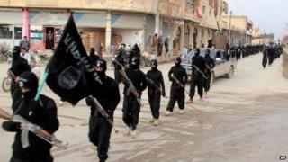 Islamic State militants march with the IS flag in Raqqa Syria on Jan 2014