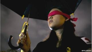 A student protester holds an umbrella with messages written on the fabric in front of Liberty Square to show support for Hong Kong pro democracy rallies on 1 October 2014 in Taipei, Taiwan