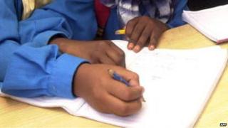 Somali girls write during a class session in the UN High Commissioner for Refugees (UNHCR) camp in Kharaz, Yemen, on 25 April 2006