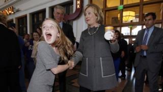 Macy Friday shakes the hand of former Secretary of State Hillary Clinton.