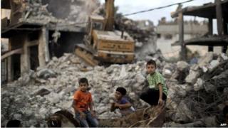 Children sit amid rubble in Shejaiya, Gaza (12/10/14)