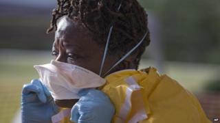 A woman puts on a surgical mask during hospital Ebola training in Alabama.