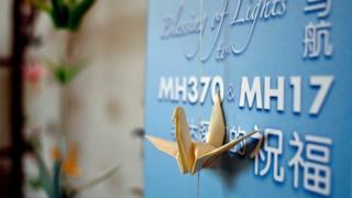 Origami paper cranes hang on a board offering prayers and condolences to the Malaysia Airlines MH370 and MH17 victims and their families at a Chinese bereavement centre in Kuala Lumpur on September 9
