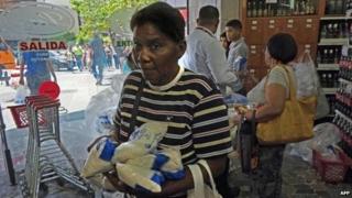People shop at a supermarket in Caracas on 29 October, 2014