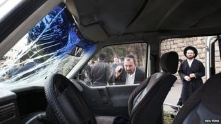 An ultra-Orthodox Jewish man looks into the vehicle of a Palestinian motorist who rammed into pedestrians near the scene of the attack in Jerusalem November 5, 2014