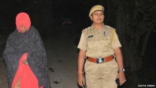 The 45-year-old woman (left) with a police officer
