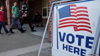 A flag-emblazoned sign stands outside a voting booth in Connecticut.