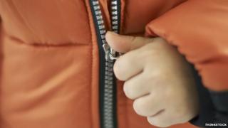Child zipping up winter jacket