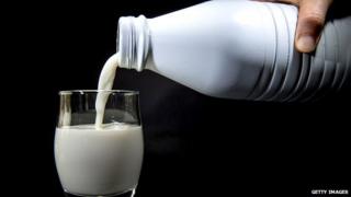 A photograph of milk being poured into a glass.