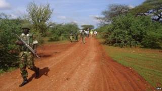 A Kenyan soldier patrols the scene of an attack on a bus, some 30km from Mandera town, in northern Kenya - 22 November 2014