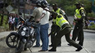 Police frisks a motorcyclist in Quibdo, Choco province