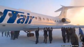 The passengers pushing the plane