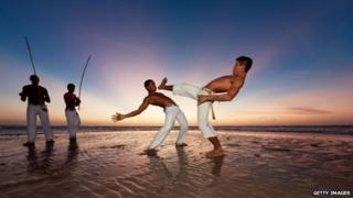 Capoeira dancers on a beach in Brazil