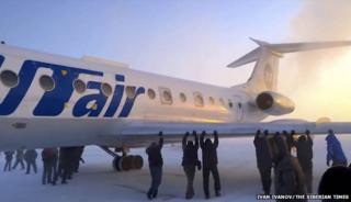 Passengers pushing plane