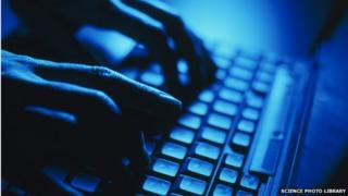 A close-up of hands using a laptop keyboard