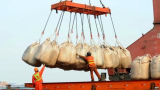 Workers unload goods from a ship at the port in Lianyungang, east China's Jiangsu province