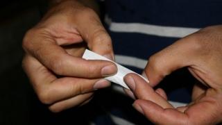 A man rolling a cigarette