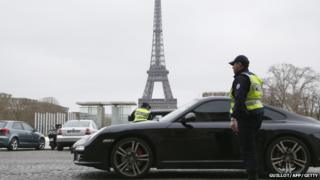 Police officers control cars in front of the Eiffel Tower, in Paris, on March 17, 2014