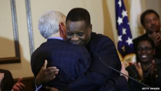 Emergency Manager Kevyn Orr (R), receives a hug from Michigan Governor Rick Snyder (L)