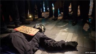 Man lies on the street while police watch