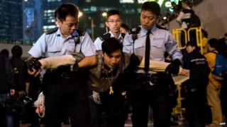 A pro-democracy protester (C) is arrested after police cleared a major pro-democracy protest camp next to the central government offices in the Admiralty district in Hong Kong on 11 December 2014.