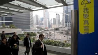 Government officials walk on the bridge outside the government headquarters in Hong Kong Friday, Dec. 12, 2014.