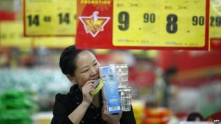 A sales girl packs goods in a supermarket in Huaibei, central China's Anhui province