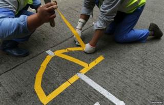 Workers remove a logo left by pro-democracy protesters in the shape of an umbrella during a clearance at the last "Occupy" protest site blocking a main road at Causeway Bay shopping district in Hong Kong