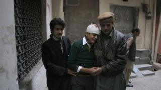 Relatives comfort injured student Mohammad Baqair in Peshawar, 16 December