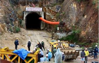 Workers and rescuers stand in front of the entrance of a tunnel at the Da Dang- Da Chomo hydroelectric power plant in Lac Duong district, central highland province of Lam Dong on 16 December 2014