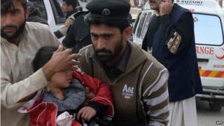 An injured girl is carried to hospital in Peshawar, 16 December