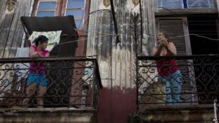 Two women talk on a Havana balcony