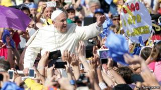 Папа Франциск машет школьникам на площади Святого Петра в мае 2014 года