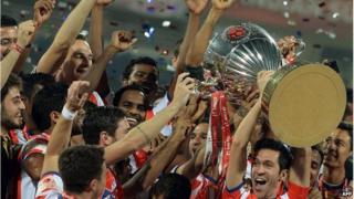 Atletico de Kolkata player Luis Garcia lifts the trophy as he celebrates with teammates after winning the Indian Super League (ISL) final football match against Kerala Blasters at The D.Y. Patil stadium in Navi Mumbai on December 20, 2014