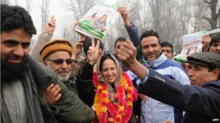 Peoples Democratic Party (PDP) candidate Asiya Naqash (C) gestures after winning the Hazratbal constituency, in Srinagar on December 23, 2014