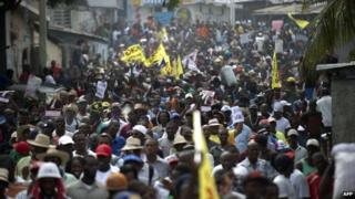 Anti-government protesters march through Port-au-Prince on 16 December, 2014 calling for Haitian President Michel Martelly's resignation.