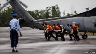 Members of the search and rescue team carry the body of a victim of the AirAsia flight QZ8501 at Iskandar airbase - 4 January 2015