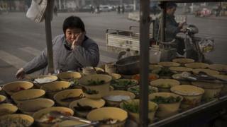 A Chinese food vendor waits for customers at a market on November 21, 2014 in Hebei just outside Beijing, China